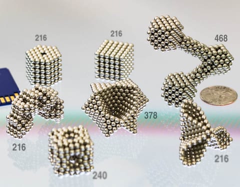 Micromagnet builds of 216 to 468 spheres, beside an SD card and a dime for scale
